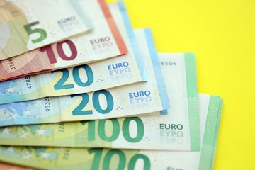 Big amount of european euro currency money notes on yellow color table close up