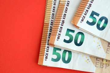 Big amount of european euro currency money notes on red color table close up