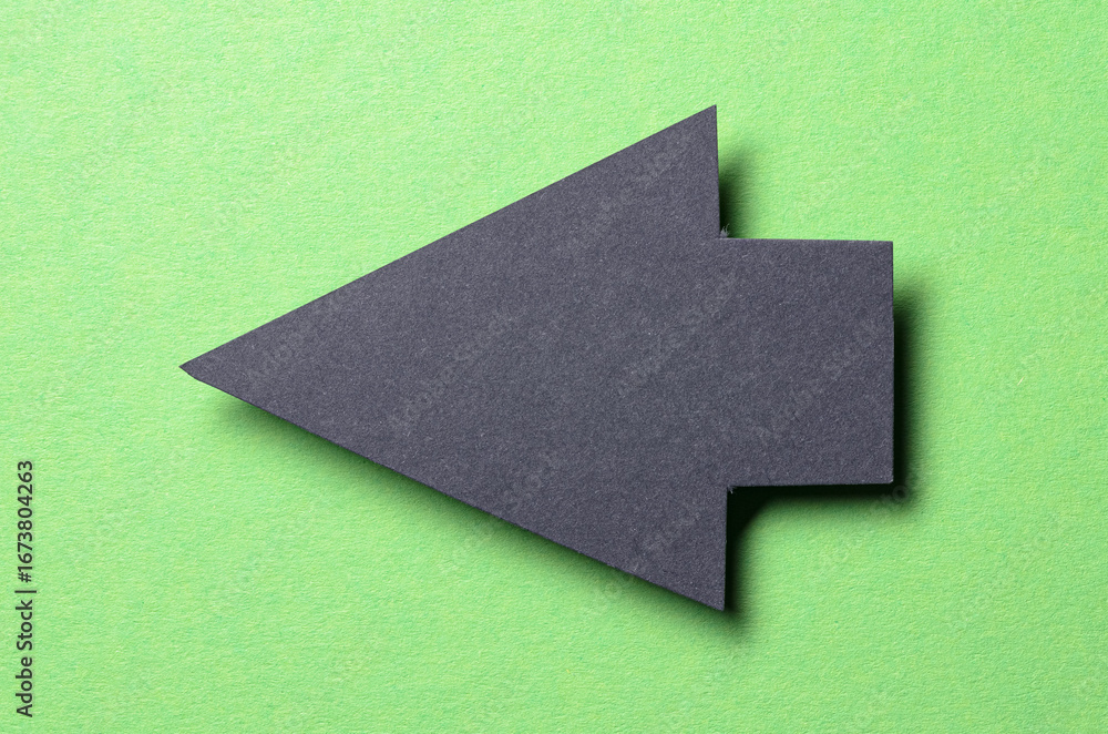 Aufkleber black cut out blank paper cardboard arrow direction sign with copy space for text on green backgroun