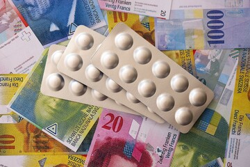 Swiss franc banknotes and medicine pills. The current francs money bills and drugs lies on table