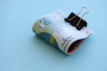 Swiss franc banknotes on blue background. The current francs money bills lies in big amount