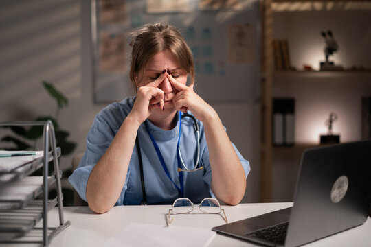 physician nurse diagnosis disease working over hours suffering eyes ache and stress in hospital office on night shift. Medicine and Health care service