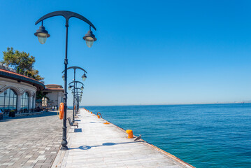 Serenity at the waterfront pier with bright lamps and clear skies in a bustling city
