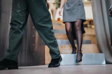 A man and a woman descending stairs in a professional environment, suggesting collaboration,...