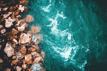 Aerial view of turquoise water flowing past rocks