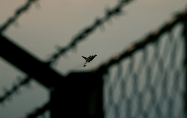 Fighter jet in mid-air, performing a high-speed pass with smoke trails trailing behind it. The jet...