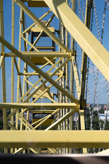 Naklejka premium A bright yellow Ferris wheel structure beautifully set against the clear blue sky overhead
