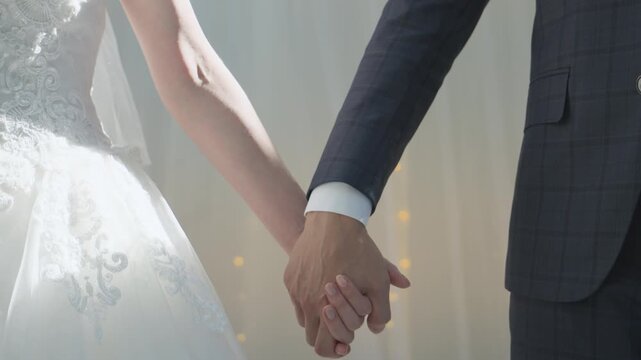 Couple holding hands, fingers intertwined