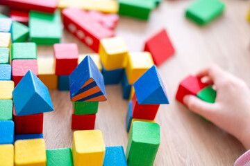 Child fun playing with wooden toys, play time, Colorful blocks and figures on table. Early...