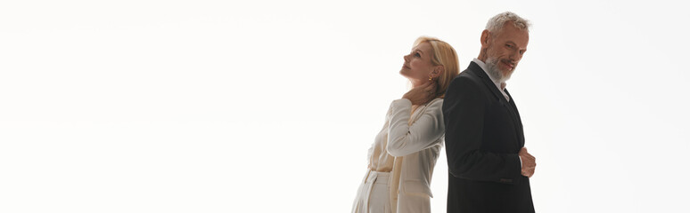 Senior couple shares a tender moment in stylish outfits with a minimalist backdrop