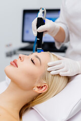 A young woman undergoing a hydra peeling procedure at a beauty salon. Concept skin care for...