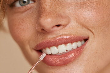 Fototapeta premium Girl with braces cleaning teeth with interdental bruh on beige background, cloeup