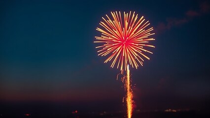 Single firework bursting in red and gold against twilight sky, radiant sparks trailing over distant city lights.