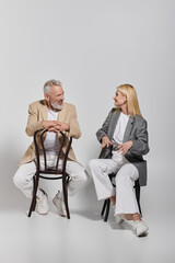 Fototapeta premium Stylish senior couple enjoying a joyful moment together while seated in a chic setting