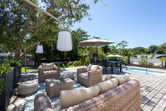 Un salon de jardin ext&eacute;rieur sur une terrasse en bois dans le jardin d'une villa moderne