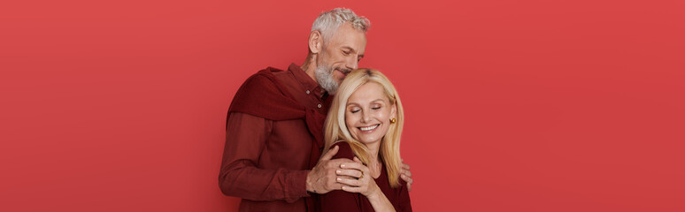 Senior couple exudes love and style with modern attire against a vibrant backdrop