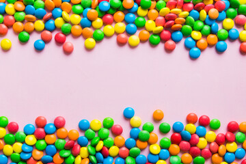 Obraz premium Mixed collection of colorful candy, on colored background. Flat lay, top view. frame of colorful chocolate coated candy