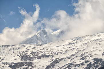 Snowy mountain peak and clouds