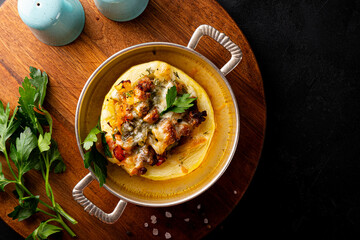 Round zucchini baked with minced meat and cheese on the black background top view, photo with copy...