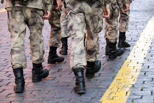 Legs of soldiers of military forces in camouflage. Men walking down the city street, mobilization concept
