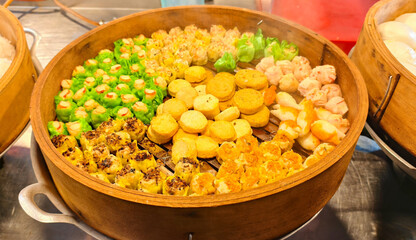 A variety of Dim Sum dishes, presented in a traditional bamboo steamer basket. 