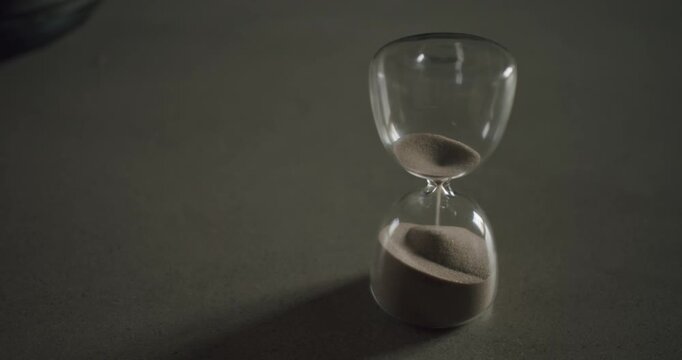 An hourglass with sand slowly falling, measuring the passage of time. anticipation, and the inevitable flow of time. time management, deadlines, or the fleeting nature of moments.