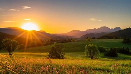 Obraz premium vibrant sunset casts golden light over lush fields and mountains in a serene landscape