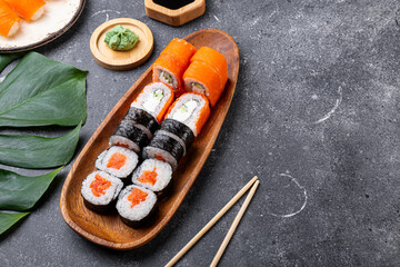 A vibrant assortment of fresh sushi, including nigiri, rolls, and sashimi on grey background copy space for text