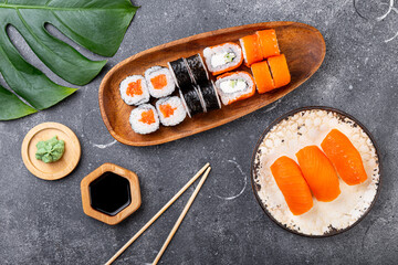 A vibrant assortment of fresh sushi, including nigiri, rolls, and sashimi on grey background