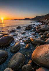 Obraz premium Serenity meets the seashore: A beautiful sunrise colors a rocky beach