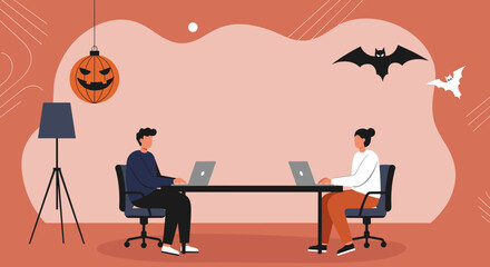 Two people working productively on laptops in a creatively decorated office space with Halloween elements, representing seasonal business or teamwork.