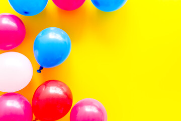 Colorful balloons frame on yellow background top-down frame copy space