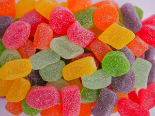 Assorted colorful jelly candies with various flavors, sugar-coated and chewy, displayed in vibrant...