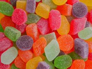 Assorted colorful jelly candies with various flavors, sugar-coated and chewy, displayed in vibrant...