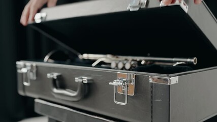Jazz singer plays on a trumpet in modern studio. Playing live jazz concert. Passion for music. Close Up hand of young trumpet player. A man in a suit opens a suitcase where a new trumpet is located. - Powered by Adobe