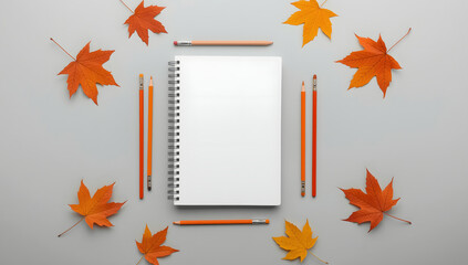 “Blank White Spiral Sketchbook with Paintbrushes, Pencils, and Autumn Leaves – Minimalist Art Workspace Flat Lay”
