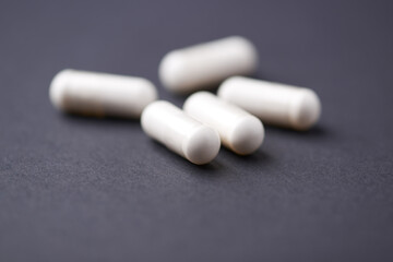 HMB capsules on dark background. Soft focus. Close up. Copy space.
