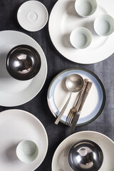 Top view of an empty plates, bowls, glasses and cutlery placed on a black chalkboard background. Flat lay. Top view. Food concept.