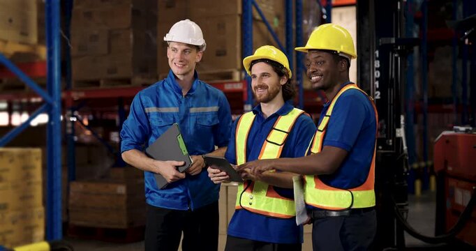 group of multicultural warehouse workers smiling together showing positive teamwork during break near forklift inside distribution center logistic working environment with pallet in background