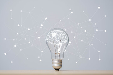 A lightbulb with a brain illustration inside sits on a table, surrounded by a network of connected dots on a gray background.