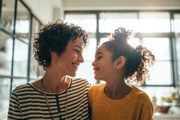 Happy joyful mother and daughter enjoying bonding time at home indoors with sunlight.