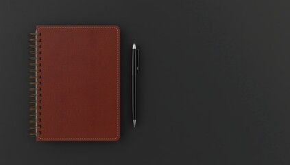 A closed notebook with a brown cover and a pen lying on a dark background - a minimalist work set.