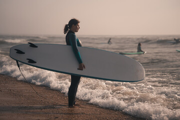 Surfing woman with a surfboard on a beach