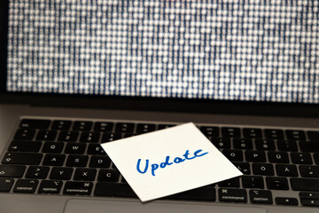 Computer software updates, note on the keyboard of a laptop. Technology, system update, new release, system configuration, computer language.