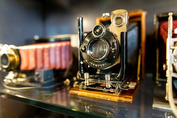 Antique cameras on display shelf in museum or vintage collection.