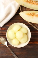 Cut ripe melon on wooden table, flat lay