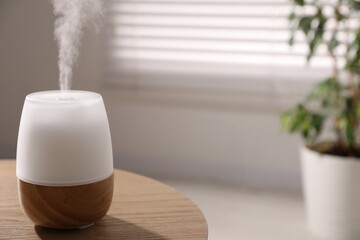 One stylish aroma lamp on wooden table indoors, closeup. Space for text