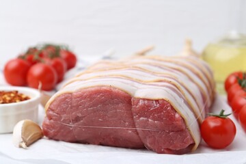 Piece of raw beef meat, tomatoes and spices on table, closeup