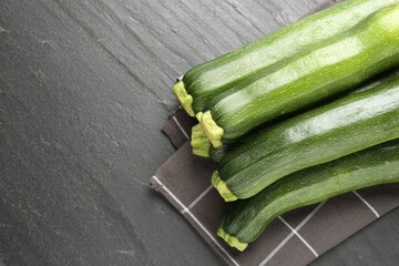 Fresh ripe zucchinis on black table, top view. Space for text