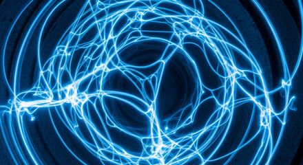 Naklejka premium Intricate network of glowing blue lines weaves across a dark background, creating a mesmerizing abstract pattern with a sense of energy and interconnectedness, suggesting advanced technology.